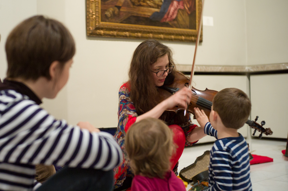 Muziciană cântând la vioară. Program special în Galeria de Artă Europeană